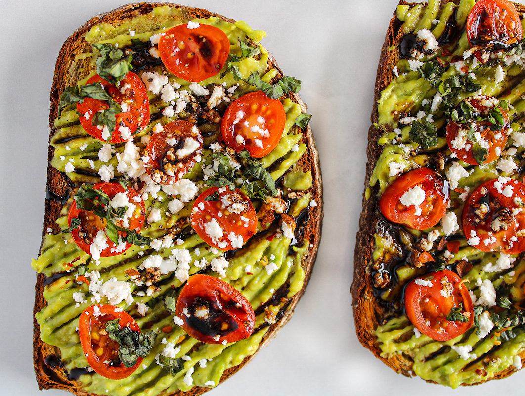 Avocado toast with balsamic glaze, feta cheese, and tomatoes